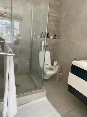 a bathroom with a toilet and a glass shower at Bright apartment in Cape Town