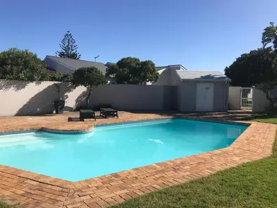 a large blue swimming pool in a yard at Bright apartment in Cape Town