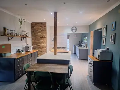 a kitchen with a table and chairs in a room at KeMi Country House in Caledon