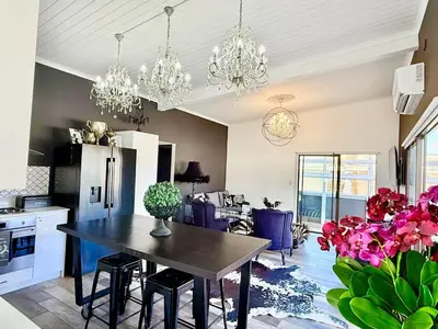 a kitchen and dining room with a table and chairs at Dior Maison de Reve- Private Penthouse in Stellenbosch