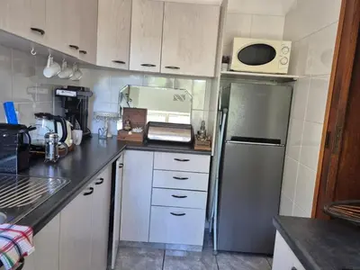 a kitchen with a stainless steel refrigerator and white cabinets at Afton Safari Lodge in Cape Town