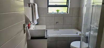 a bathroom with a tub and a toilet and a sink at 33 Langeberg Heights in Cape Town
