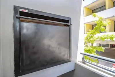 a large screen television on the side of a building at 18 on The Den Studio Apartment in Stellenbosch