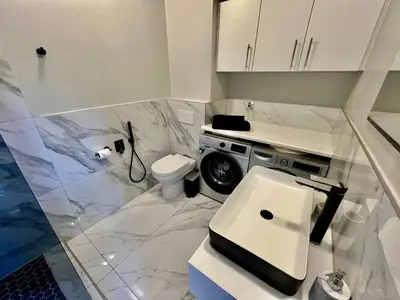 a white bathroom with a sink and a toilet at Enchanted View from Above in Stellenbosch