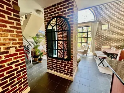 a room with a brick wall and an archway at Enchanted View from Above in Stellenbosch