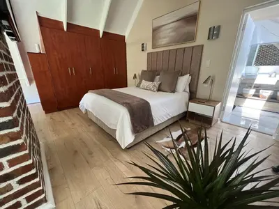 a bedroom with a bed and a plant in it at Enchanted View from Above in Stellenbosch