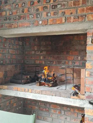 a brick oven with a fire in it at Flamingle at Coot in Cape Town