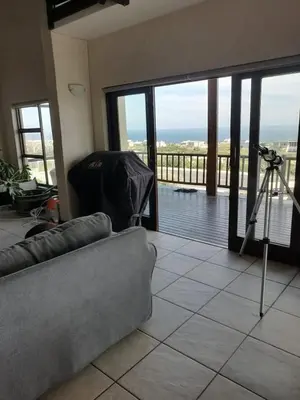 a living room with a couch and a view of the ocean at LaMer in Bettyʼs Bay