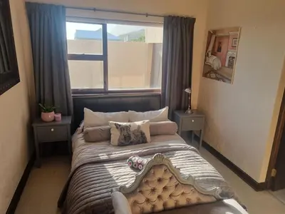 a bed in a room with a large window at La Mer in Bettyʼs Bay