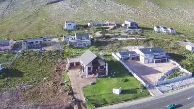 an aerial view of a house on the side of a hill at La Mer in Bettyʼs Bay