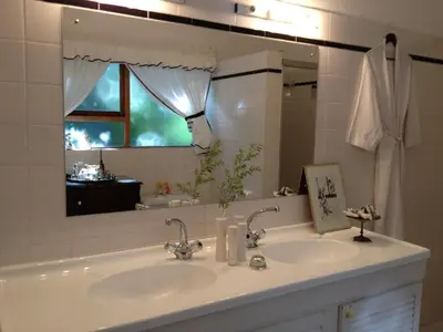 a bathroom with two sinks and a large mirror at Tolbos Grand in Somerset West