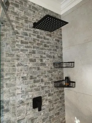 a bathroom with a brick wall with two shelves at Tide's whisper in Hermanus