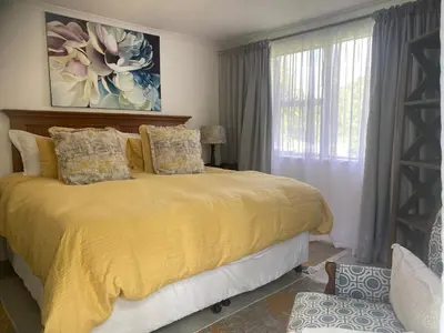a bedroom with a yellow bed with a window at 8 Sleeper, 4 Bedroom Home in Franschhoek in Franschhoek