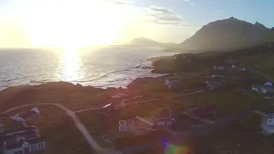an aerial view of the ocean with houses and a rainbow at La Mer in Bettyʼs Bay