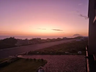 a view of a road at sunset from a house at La Mer in Bettyʼs Bay