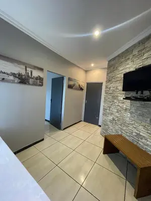 a living room with a stone wall and a tv at Ayan Contractors & Student Accommodation in Avondale