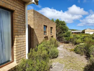 a brick building with a window on the side of it at Betty's Bay Quaint Cottage in Bettyʼs Bay