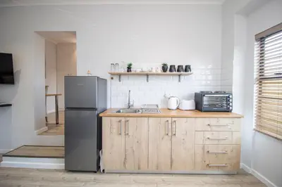 a kitchen with a refrigerator and a sink at Lin's Snooze Inn in Strand