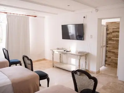 a room with a table and chairs and a television at Morgenzon Farm in Wellington