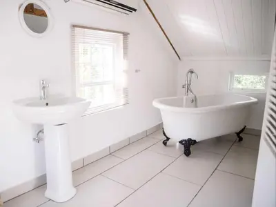 a white bathroom with a tub and a sink at Morgenzon Farm in Wellington