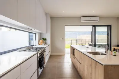 a kitchen with white cabinets and a large window at Luxury Golf Villa 710, Pearl Valley Golf Estate in Simondium