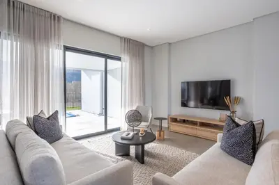 a living room with a white couch and a tv at Luxury Golf Villa 710, Pearl Valley Golf Estate in Simondium