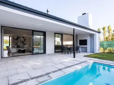 a house with a swimming pool and a patio at Luxury Golf Villa 710, Pearl Valley Golf Estate in Simondium