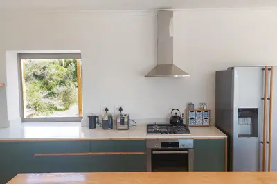 a kitchen with a stove and a refrigerator at Swallows Perch Beach Getaway - Solar Backup in Bettyʼs Bay