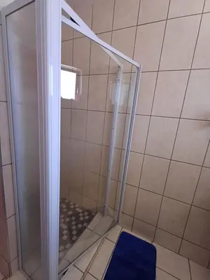 a shower with a glass door in a bathroom at Oakway Guest Suite 2 Beds 1Bath Aircon Kitchen Private in Kuilsrivier