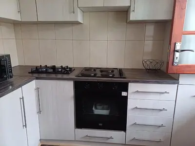 a kitchen with a black stove and white cabinets at Oakway Guest Suite 2 Beds 1Bath Aircon Kitchen Private in Kuilsrivier