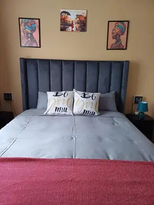 a bedroom with a large bed with a blue headboard at Oakway Guest Suite 2 Beds 1Bath Aircon Kitchen Private in Kuilsrivier