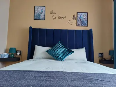 a bed with a blue headboard in a bedroom at Oakway Guest Suite 2 Beds 1Bath Aircon Kitchen Private in Kuilsrivier