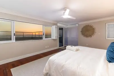 a bedroom with a bed and a view of the ocean at 