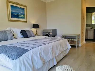 a bedroom with a large bed and a stove at 'Goldwater on Beach' - 3 Bedroom Beachfront with Balcony & BBQ - Sleeps 6 in Gordonʼs Bay