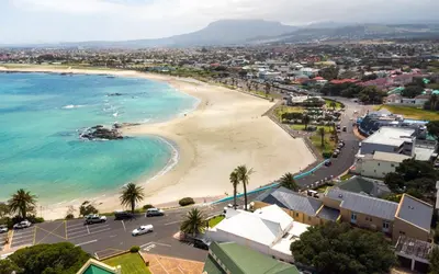an aerial view of a beach and the ocean at 'Goldwater on Beach' - 3 Bedroom Beachfront with Balcony & BBQ - Sleeps 6 in Gordonʼs Bay