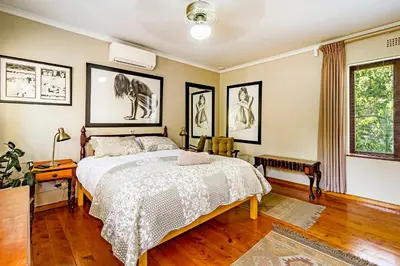 a bedroom with a bed and pictures on the walls at 5 on Paul Kruger in Somerset West