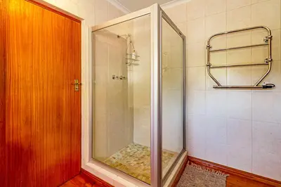 a shower with a glass door in a bathroom at 5 on Paul Kruger in Somerset West