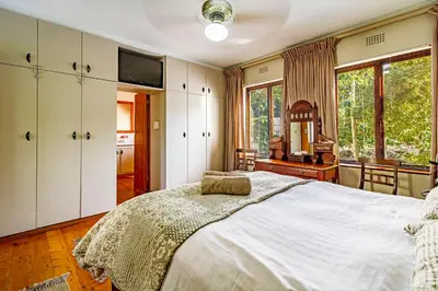 a bedroom with a large bed and a mirror at 5 on Paul Kruger in Somerset West