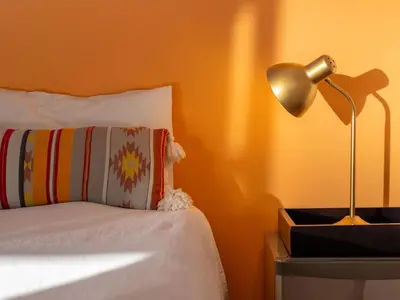 a bedroom with a bed with a lamp on a night stand at Cape Town 4U Guesthouse in Cape Town