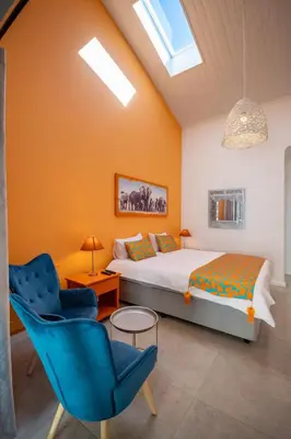 a bedroom with a bed and a blue chair at Cape Town 4U Guesthouse in Cape Town