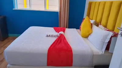 a bed with a red and white blanket and pillows at Neo & Ruks Guest Houses parow 4 in Avondale