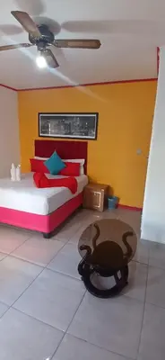 a bedroom with a bed and a table in a room at Neo & Ruks Guest Houses parow 4 in Avondale