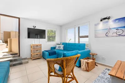 a living room with a blue couch and a tv at Suikerbossie 83 in Cape Town