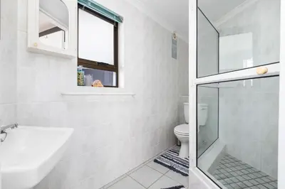 a white bathroom with a sink and a toilet at Suikerbossie 83 in Cape Town