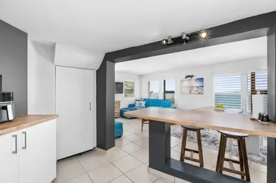 a kitchen and living room with a large wooden table at Suikerbossie 83 in Cape Town
