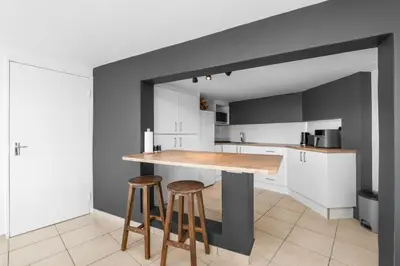 a kitchen with a counter and two stools at Suikerbossie 83 in Cape Town