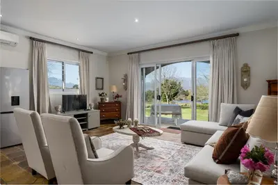 a living room with a couch and chairs and a tv at Bonne Chance Luxury Estate in Lynedoch