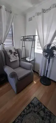 a living room with a couch and a fan at Grey Vine Cottage - Guest Room in Cape Town