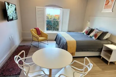 a bedroom with a bed and a table and chairs at Whale Watchers studio in Hermanus