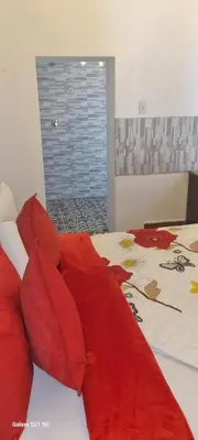 a bedroom with a bed with red pillows at Neo & Ruks Guest Houses Boston Belleville 6 in Bellville